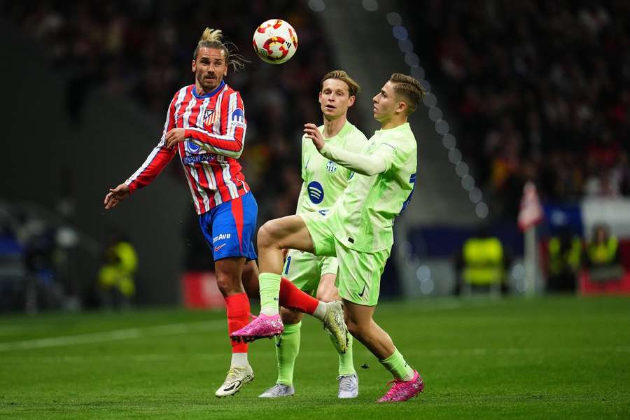 Fermín López y Frenkie de Jong, del Barcelona, desafían a Antoine Griezmann, del Atlético de Madrid. Fermín López y Frenkie de Jong, del Barcelona, desafían a Antoine Griezmann, del Atlético de Madrid.