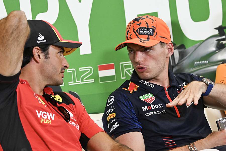 Ferraris spanske kører Carlos Sainz Jr. (L) og Red Bull Racings hollandske kører Max Verstappen taler sammen.