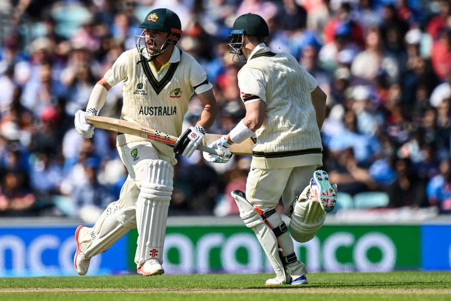 Australia's Travis Head (L) and Australia's Steve Smith run