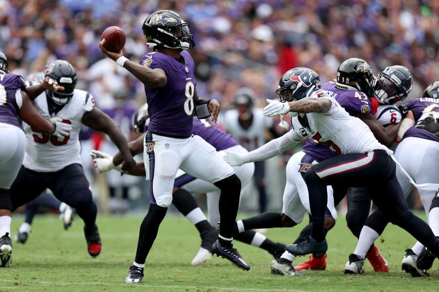 Quarterback Lamar Jackson van de Baltimore Ravens gooit onder grote druk van de Texans-defensie