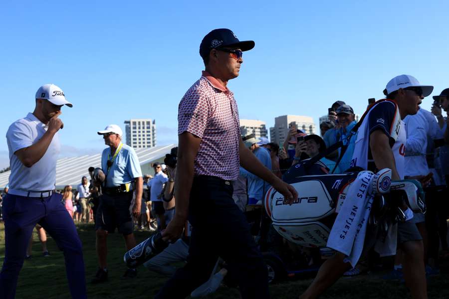 Wyndham Clark of the United States and Rickie Fowler of the United States walk from the 10th green