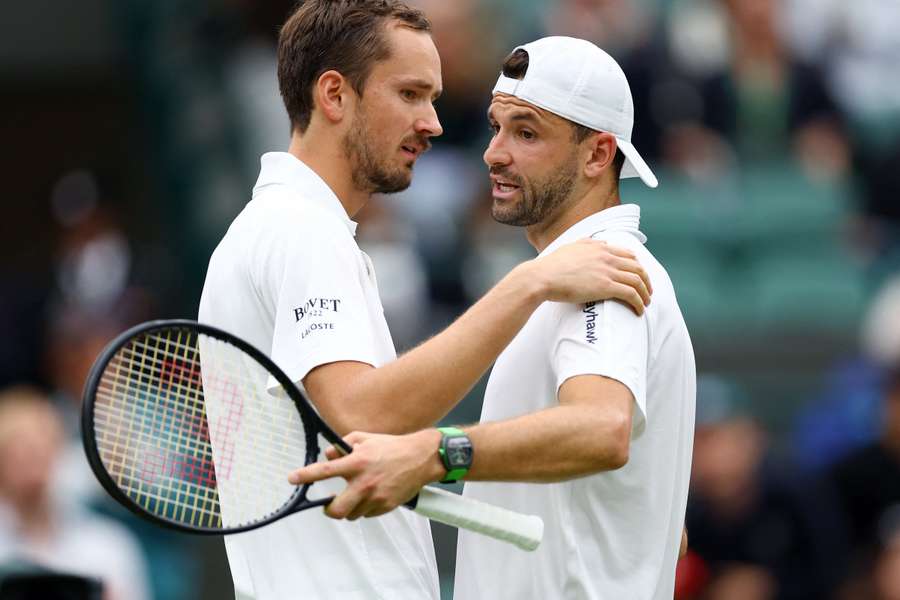 Daniil Medvedev og Grigor Dimitrov omfavner hinanden efter den forkortede kamp