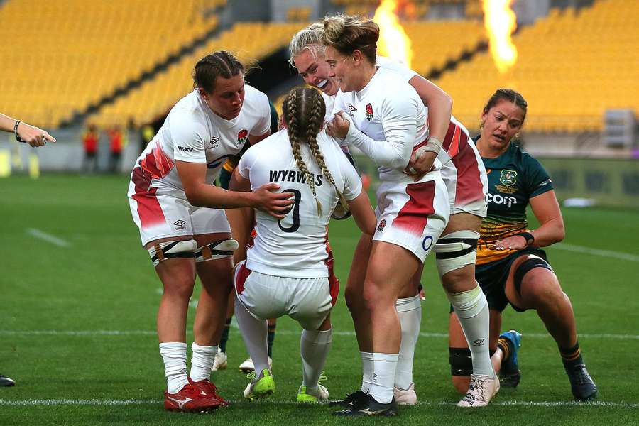 England's Ella Wyrwas (C) celebrates with teammates after scoring a try