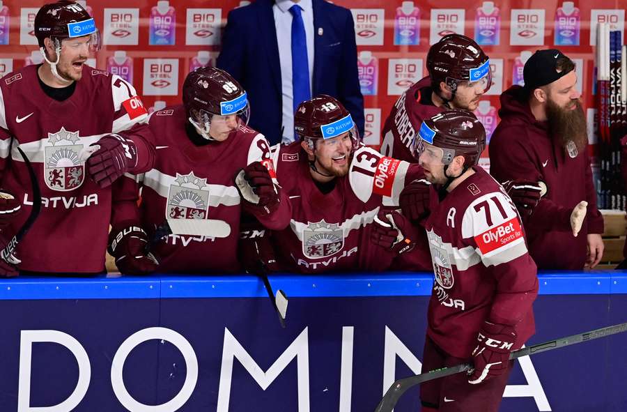 Latvia's players celebrate scoring against Slovenia