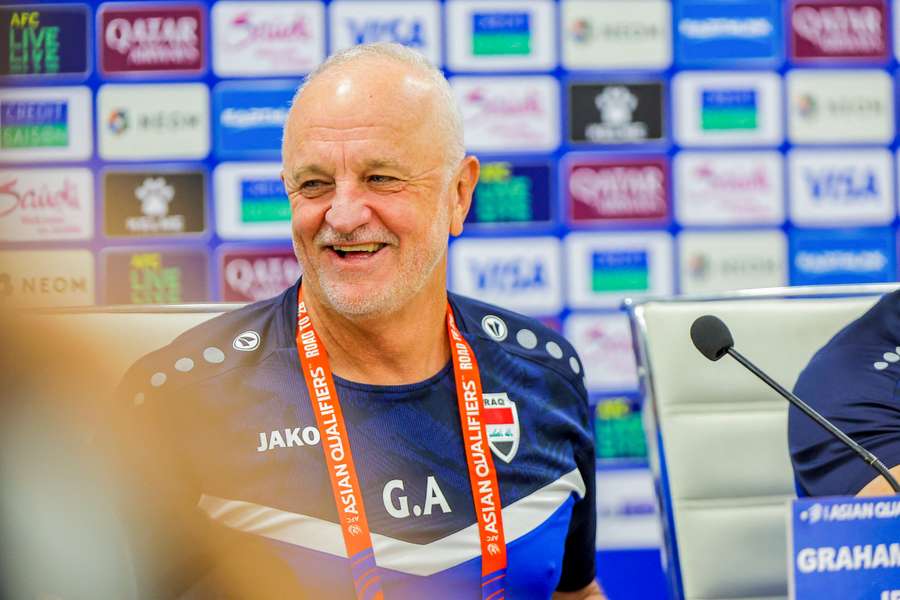 Graham Arnold shares a laugh at an Iraq national team press conference. 