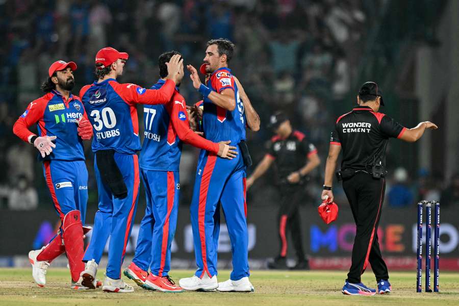 Mitchell Starc (2R) celebrates with teammates after taking the wicket of Rajasthan Royals' Dhruv Jurel