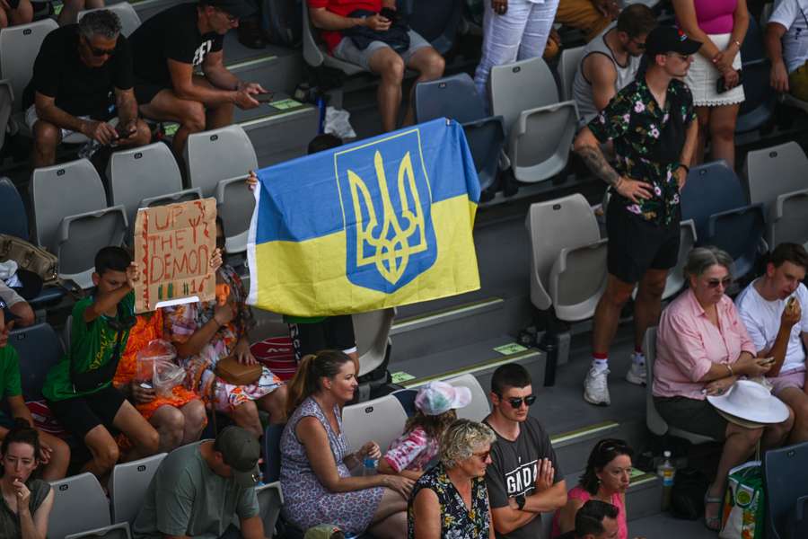 Un seguidor levanta una bandera de Ucrania durante un partido del Open de Australia.