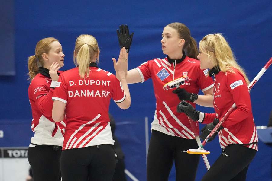 Denmark team members in action during the match against Scotland at the World Women's Curling Championship