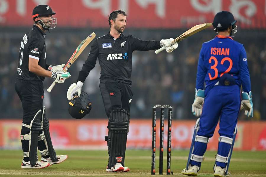 New Zealand's Devon Conway (C) celebrates after scoring a century (100 runs) as his teammate Daryl Mitchell (L)