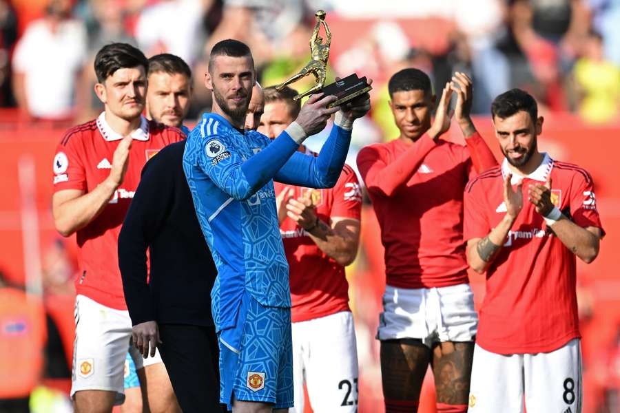 Manchester United's Spanish goalkeeper David de Gea is applauded by teammates as he holds up the golden glove trophy