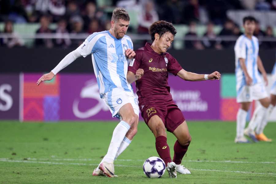 Vissel Kobe's Yuya Kuwasaki, right, competes for the ball with Ulsan HD's Milosz Trojak 