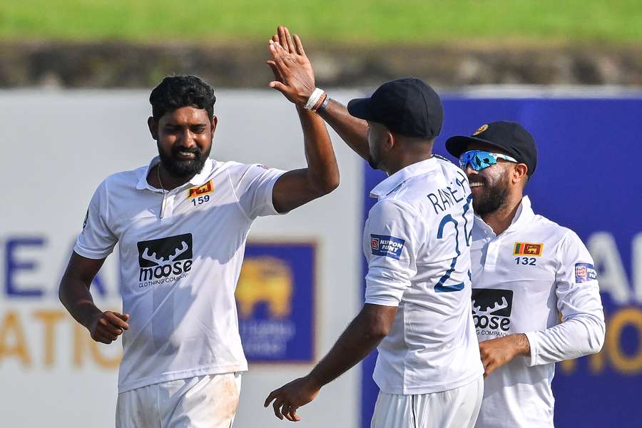 Sri Lanka's Prabath Jayasuriya (L) celebrates with teammates