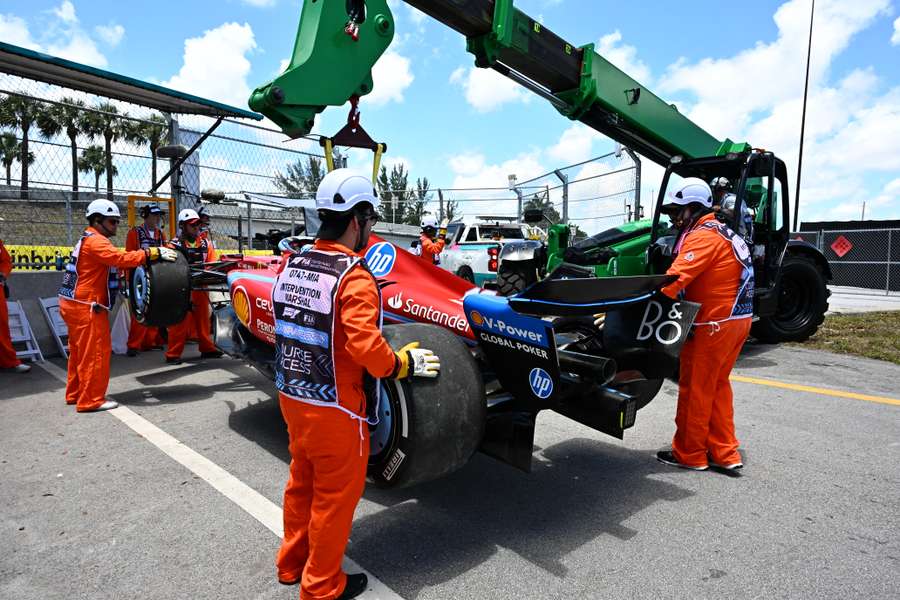 El coche de Leclerc, montado en la grúa por los operarios