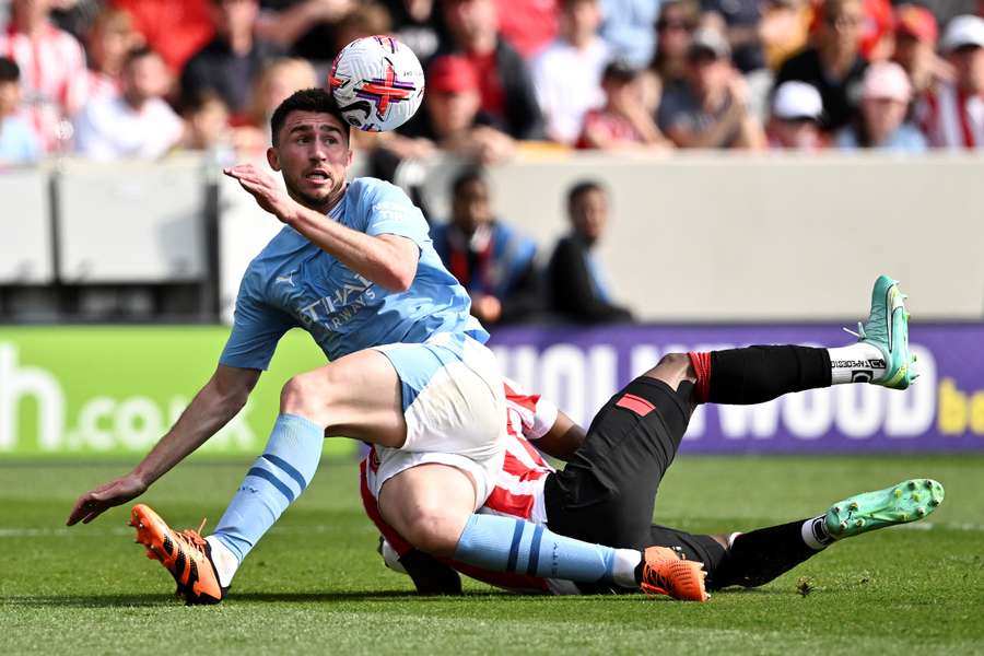 Brentford's Nigerian midfielder Frank Onyeka (back) challenges Manchester City's French defender Aymeric Laporte during the English Premier League football match between Brentford and Manchester City