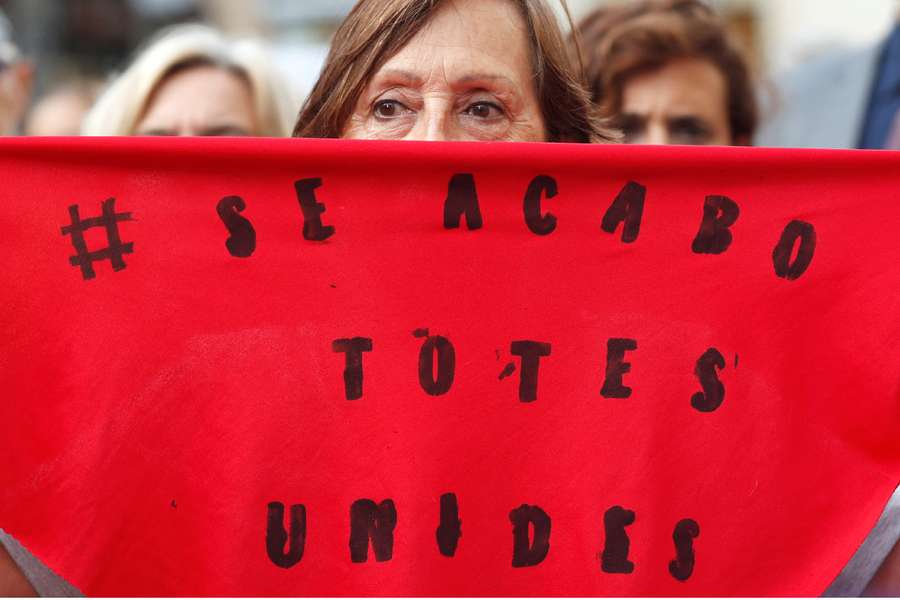 A woman holds a scarf that reads "It's over, All Together" during a protest against Rubiales