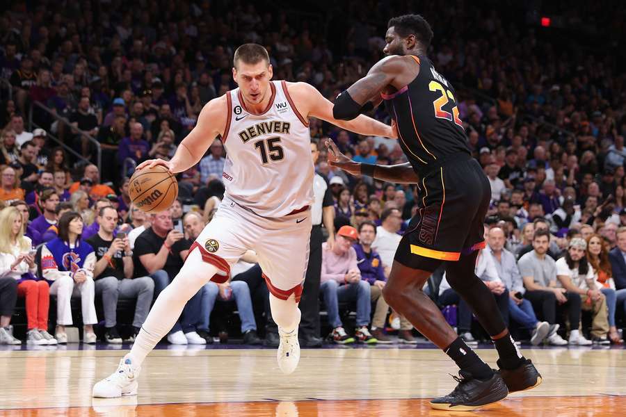 Nikola Jokic of the Denver Nuggets drives the ball past Deandre Ayton of the Phoenix Suns