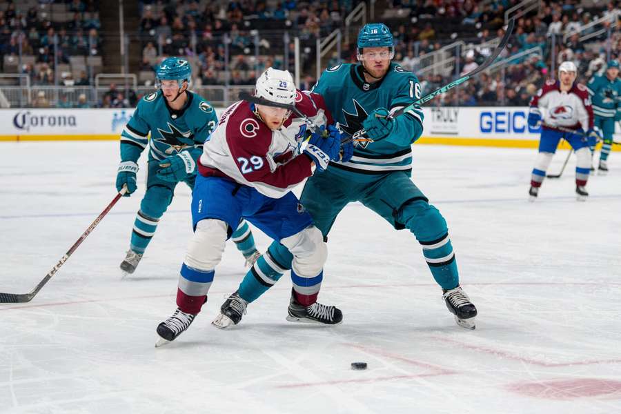 Avalanche centre Nathan MacKinnon and Sharks centre Steven Lorentz battle for the puck