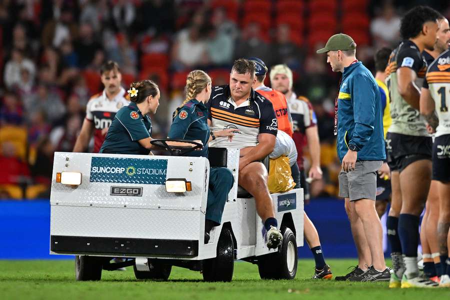 Blake Schoupp is helped off the field by his medical team in the Brumbies' 39-26 win over the Reds.