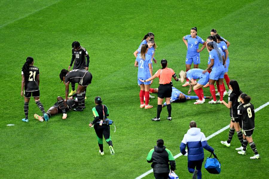 Jamaica's Kadidiatou Diani and France's Wendie Renard react after sustaining injuries