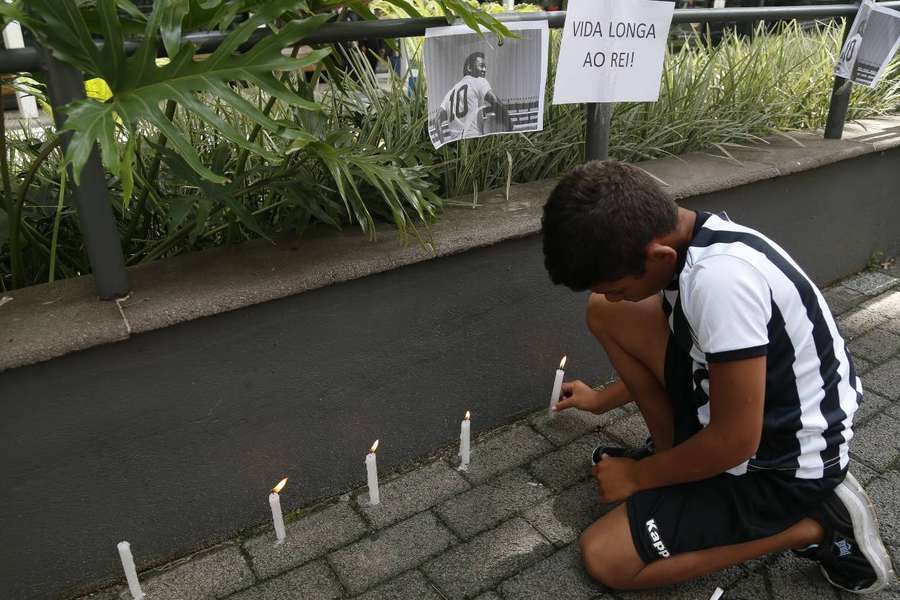 A fan lights a candle next to a picture of Pele during a vigil outside the Albert Einstein Israelite Hospital, where the star is being treated.