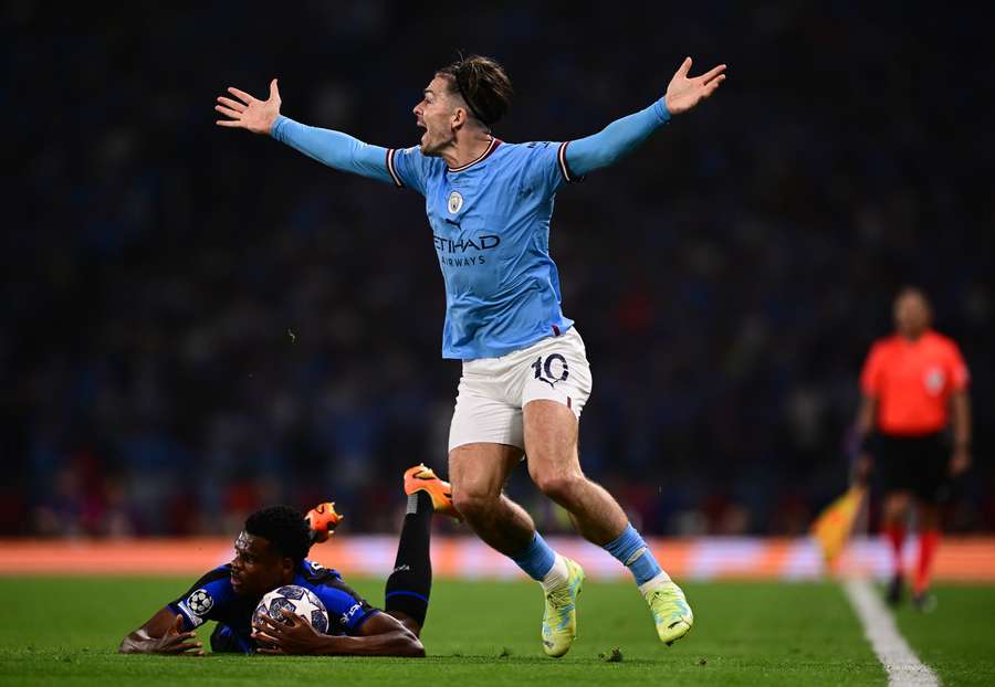 Jack Grealish reacts as Denzel Dumfries holds onto the ball