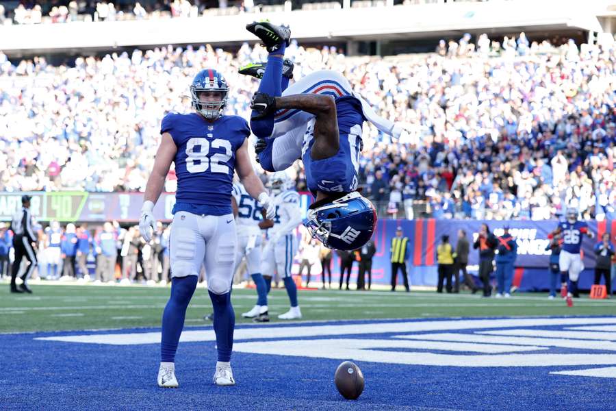 Richie James (80) viert op spectaculaire wijze een touchdown van de Giants