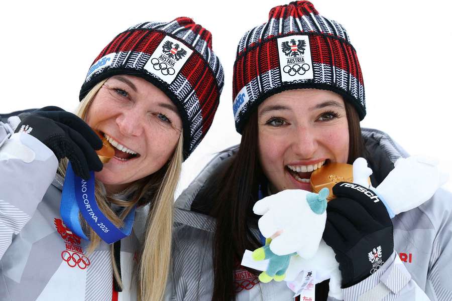 Gold medallists Ariane Raedler and Katharina Huber of Austria celebrate on the podium after winning the women's team combined 