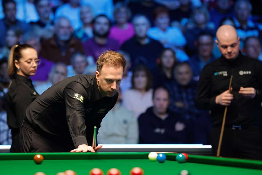 Judd Trump (m.) scheitert an Außenseiter Elliot Slessor (r.).