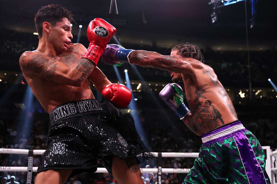 Ryan Garcia in the black trunks exchanges punches with Gervonta Davis 