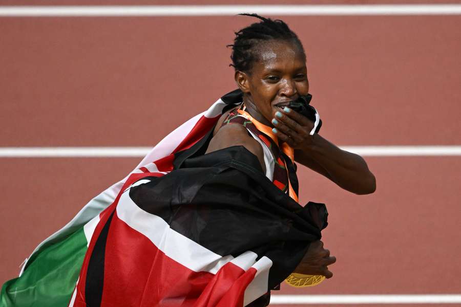 Kenya's gold medallist Faith Kipyegon celebrates with a national flag