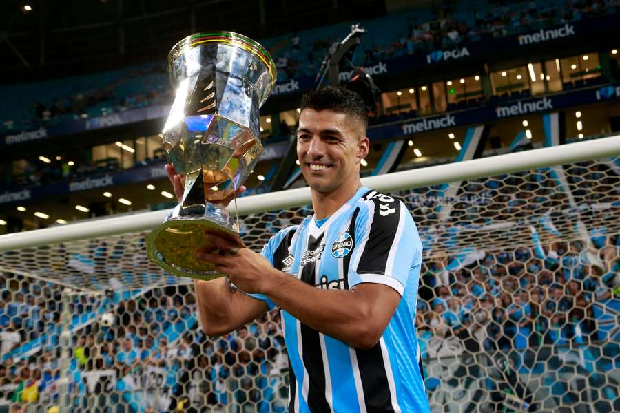 Luis Suarez lifts the state championship trophy with Gremio