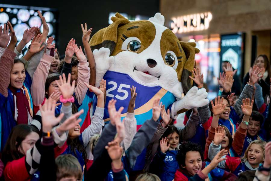 Children gather around Maddli, the mascot of the upcoming UEFA Women's EURO 2025 football tournament during its official unveiling in Geneva