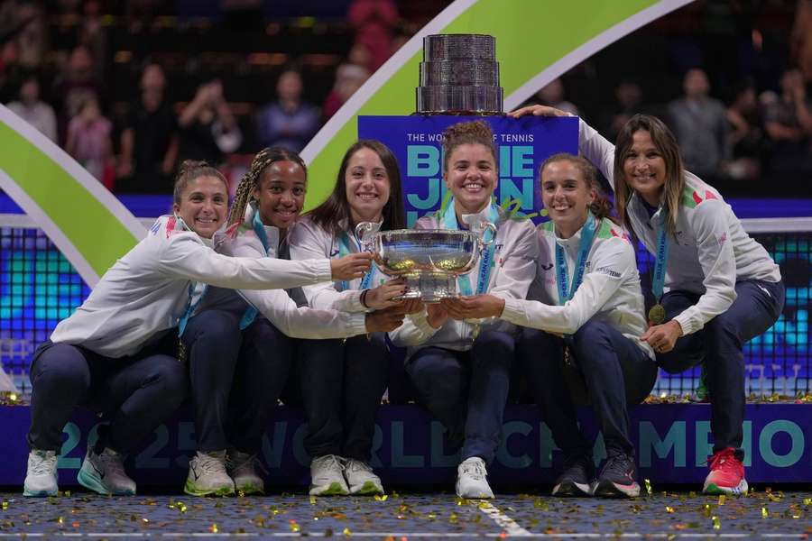 Echipa de tenis a Italiei pozează cu trofeul pe podium după ce a câștigat finala Billie Jean King Cup împotriva Statelor Unite anul trecut Echipa de tenis a Italiei pozează cu trofeul pe podium după ce a câștigat finala Billie Jean King Cup împotriva Statelor Unite anul trecut