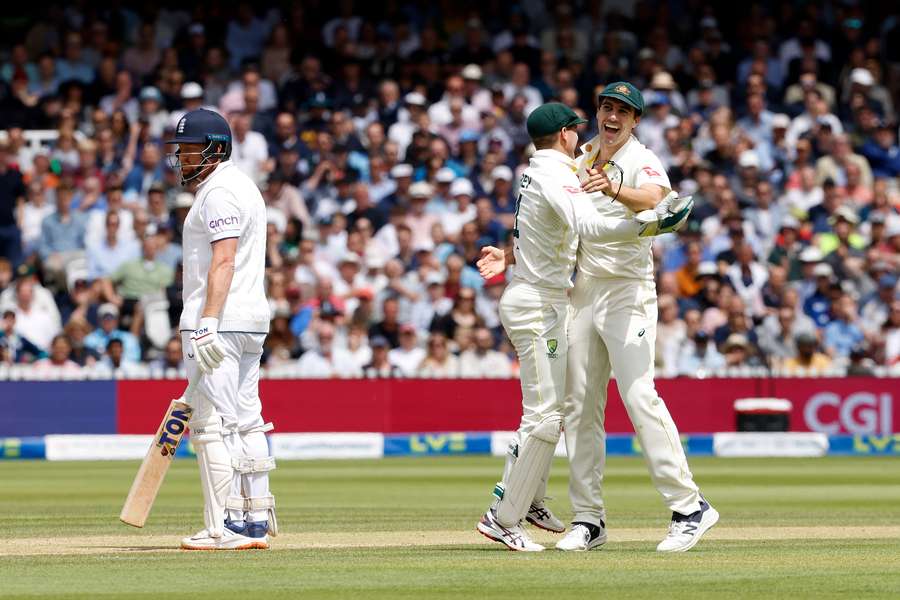 Australia's Pat Cummins (R) and Australia's wicketkeeper Alex Carey (C) celebrate taking the wicket of England's Jonny Bairstow for 10 runs