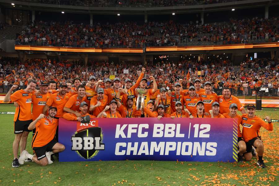 Perth Scorchers players and team staff celebrate with the trophy 