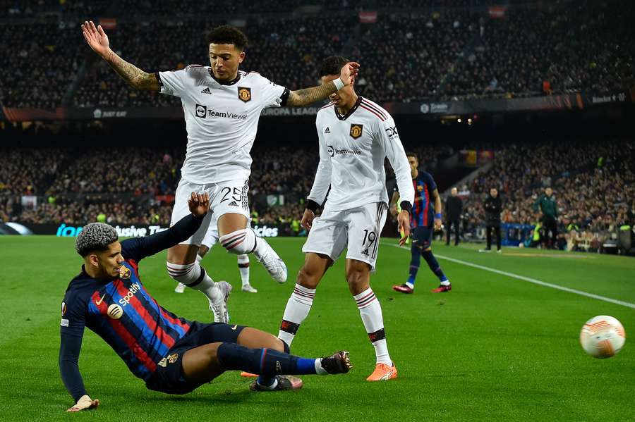 Barcelona's Ronald Araujo fights for the ball with Man Utd's Jadon Sancho and Raphael Varane