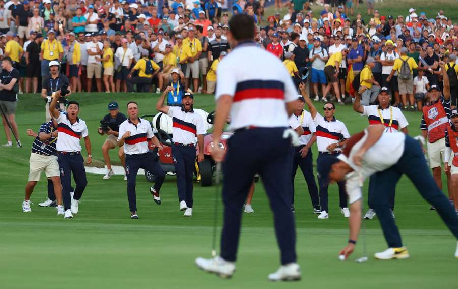 Team USA storm the 18th green after Patrick Cantlay makes a putt
