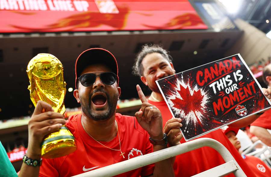Canada fans hold a replica world cup trophy inside the stadium before the match