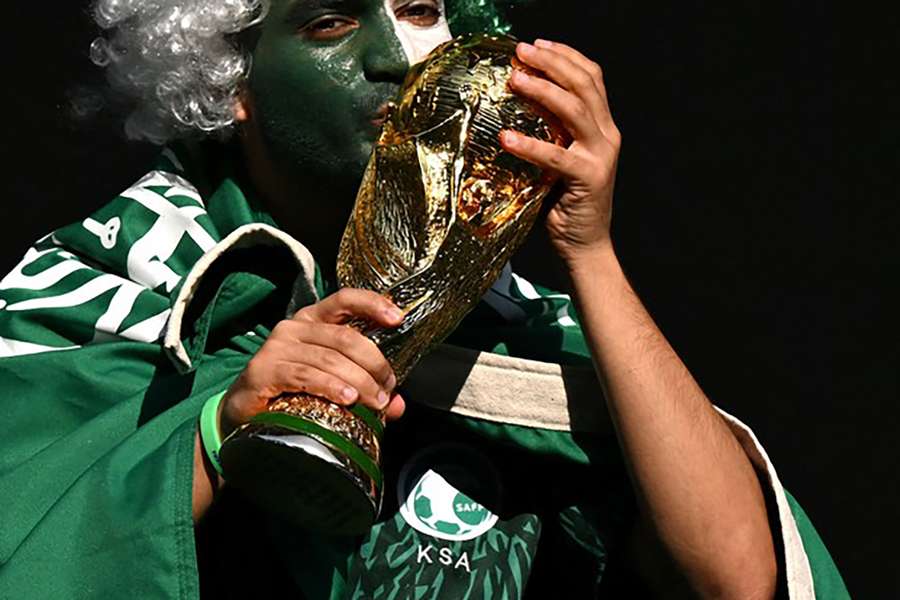 A Saudi football fan poses with a World Cup replica