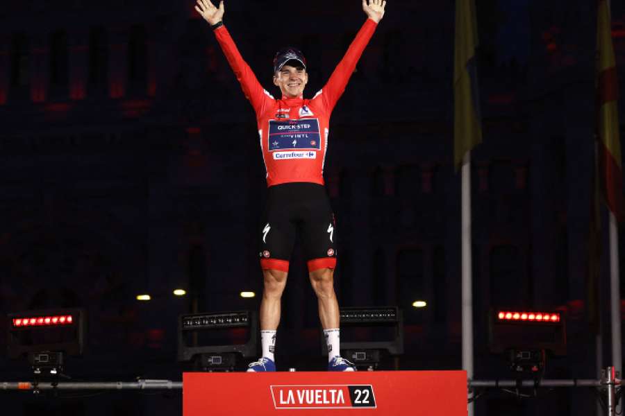 Remco Evenepoel celebrates on the podium with the trophy after winning the Vuelta a Espana