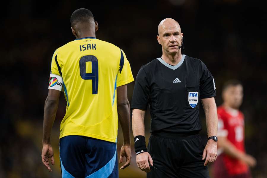 Schwedens Kapitän Alexander Isak (l.) und Referee Anthony Taylor (r.)