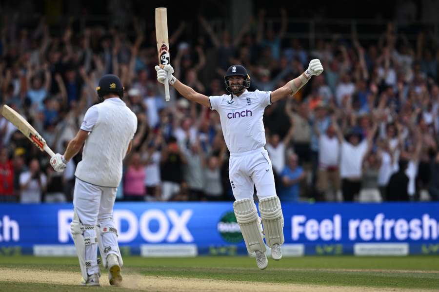 England's Mark Wood, right, celebrates with England's Chris Woakes, left, after Woakes hits a boundary to win the test match