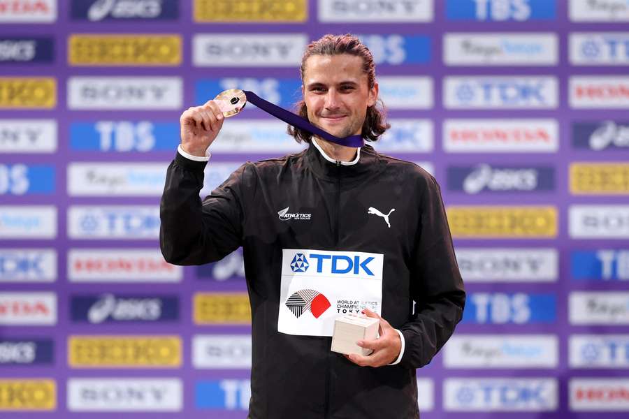 New Zealand's George Beamish poses for photographers on the podium after winning the men's 3000m steeplechase.