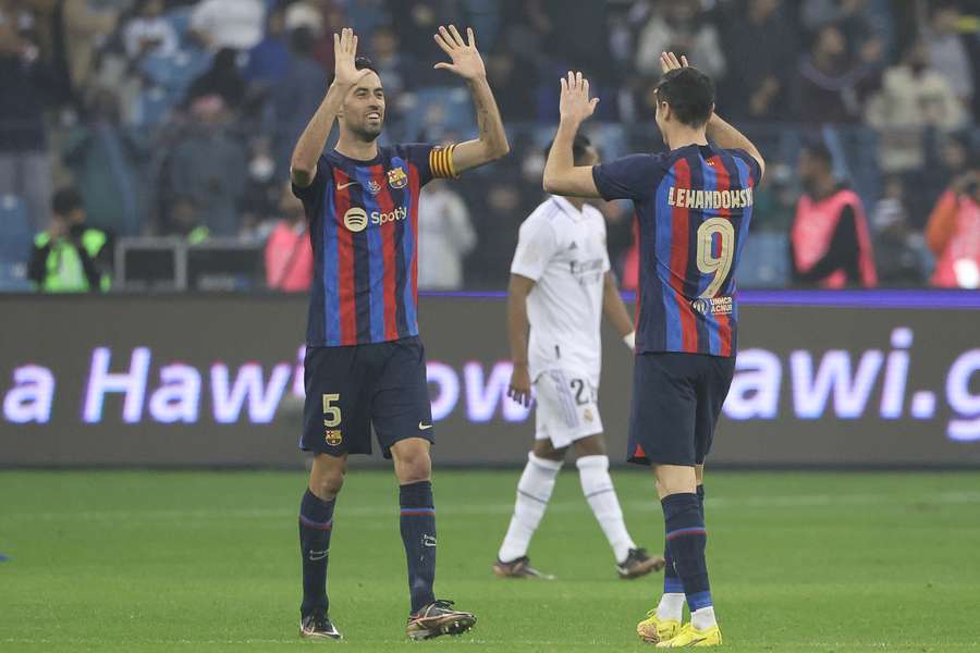 Sergio Busquets choca sus manos con Lewandowski tras ganar la Supercopa