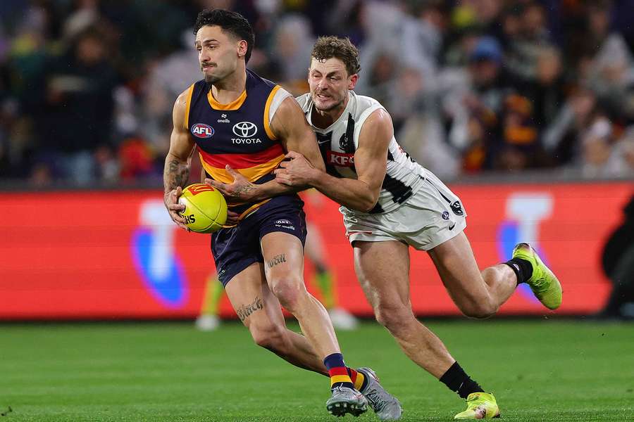 Adelaide player Izak Rankine attempts to get away from Collingwood's Harry Perryman last weekend.