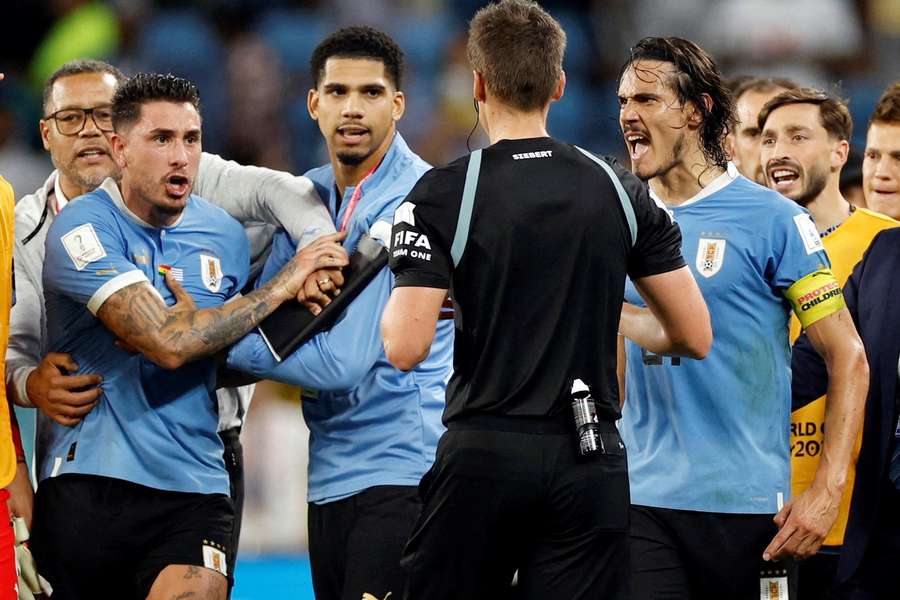 Uruguay's players argue with the referee after the Ghana match