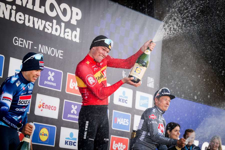 Norwegian Soren Waerenskjold celebrates his win on the podium after the 80th edition of the men's one-day cycling race Omloop Het Nieuwsblad