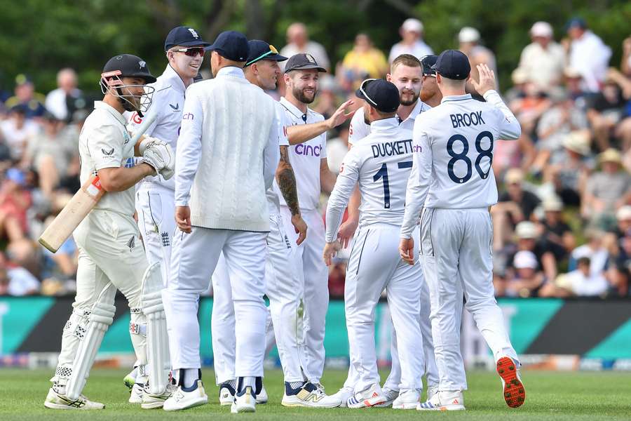 New Zealand's Kane Williamson (L) walks back to the pavilion as England players celebrate his dismissal