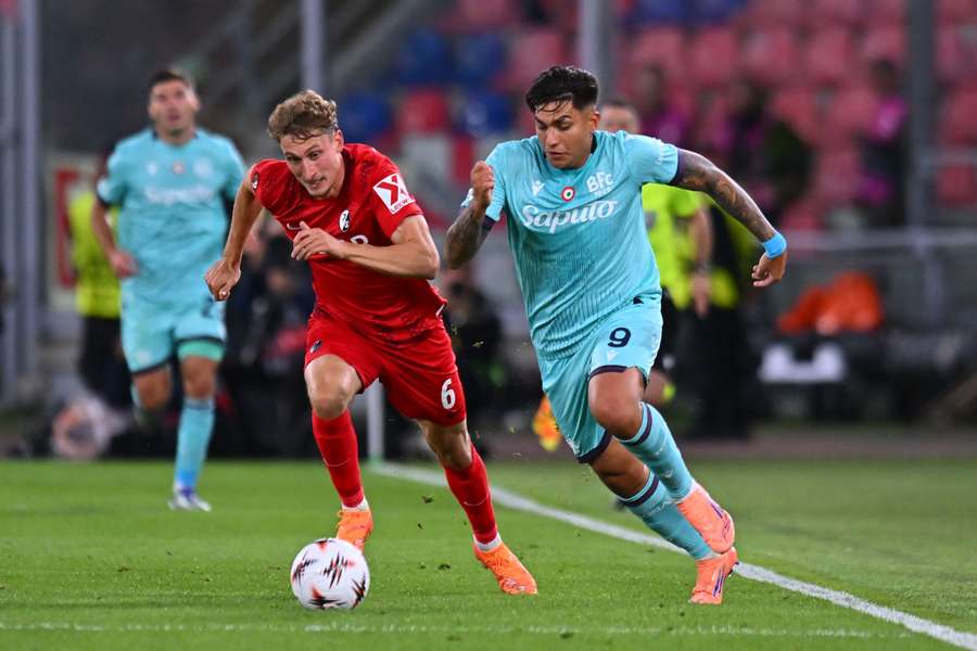 Patrick Osterhage of SC Freiburg competes for the ball with Santiago Castro of Bologna