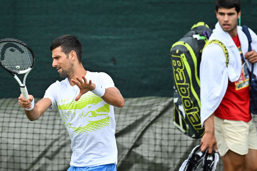 Carlos Alcaraz (R) regarde Novak Djokovic s'entraîner avant le début de Wimbledon 2023.